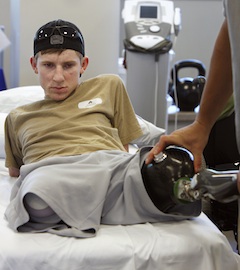 Brendan Marrocco, a 23-year-old Iraq war veteran from Staten Island, N.Y., watches as his physical therapist, Luis Garcia, takes off his prothetic legs after practicing walking at Walter Reed Army Medical Center in Washington, on May 5, 2010. Marrocco lost his arms and legs to a bomb in Iraq. A year later, he is walking again and has become an inspiration to hundreds of fellow veterans. (Ruth Fremson/The New York Times) -- STANDALONE FOR USE AS DESIRED WITH YEAREND STORIES --