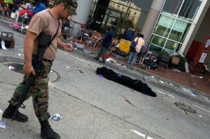 National Guard soldier walks past a covered body at the Convention Center on Sept. 3, 2005, where people took refuge after Hurricane Katrina. Source NOLA