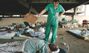 Nurse Mary Jo D'Amico fans a patient in the car park of New Orleans Memorial hospital