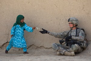 U.S. Army Private First Class Danny Comley of Camdenton Missouri, assigned to Delta Company 4th Brigade combat team,2-508, 82nd parachute infantry Regiment, receives flowers from an Afghan girl during a patrol in the Arghandab valley in Kandahar province, southern Afghanistan February 24, 2010. REUTERS/Baz Ratner (AFGHANISTAN - Tags: CIVIL UNREST CONFLICT IMAGES OF THE DAY) - RTR2ATJB