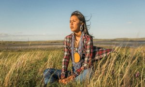a-native-american-woman-sits-on-a-bluff-in-north-dakota-at-the-pipeline-protest-source-the-guardian